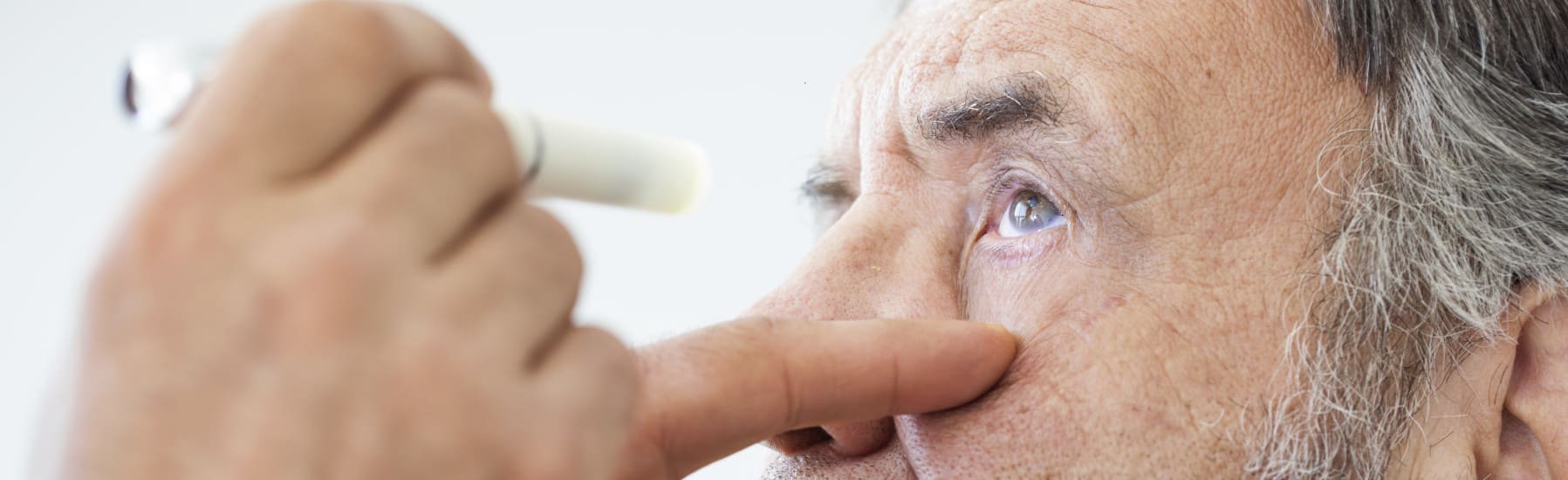Ein Arzt nutzt Diagnostikleuchten zur Untersuchung der Pupille