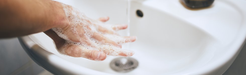 Eine Frau wäscht sich die Hände mit Seife aus einem Einbauseifenspender