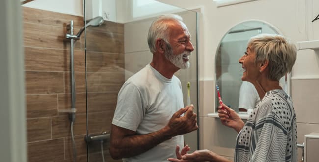 Ein älteres Paar putzt sich die Zähne in einem altersgerechten Bad