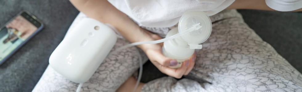 Milchpumpe für Säuglinge Eine Frau nutz eine Milchpumpe