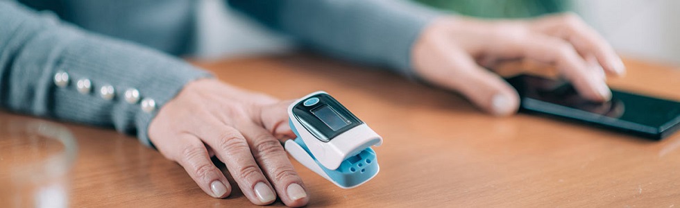 Anlegen eines Pulsoximeter-Sensors Nahaufnahme vom Anlegen eines Pulsoximeter-Sensors am Finger einer Patientin