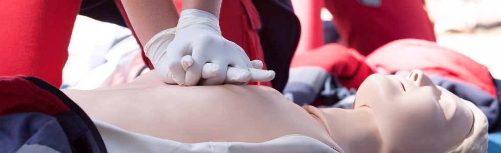 Sanitäterin übt Herzdruckmassage an einer Reanimationspuppe
