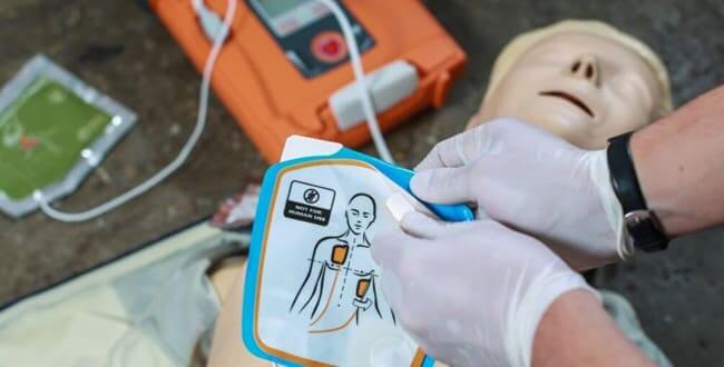 Ein Mann übt die Reanimation – es gibt verschiedene Arten von Defibrillatoren