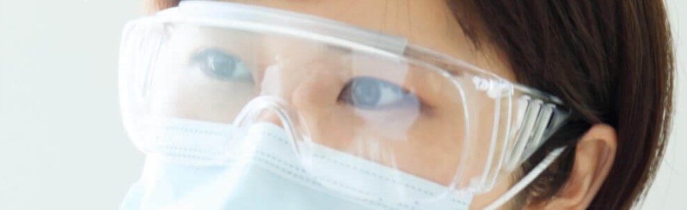 Eine Ärztin trägt bei einer Behandlung eine medizinische Schutzbrille