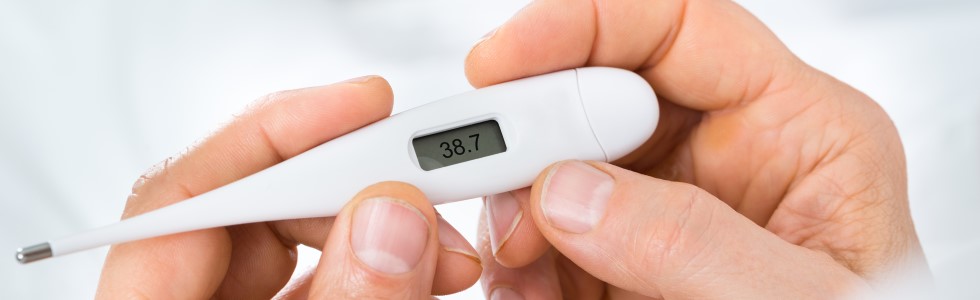 Ein Mann misst seine Körpertemperatur – er war ein Fieberthermometer kaufen